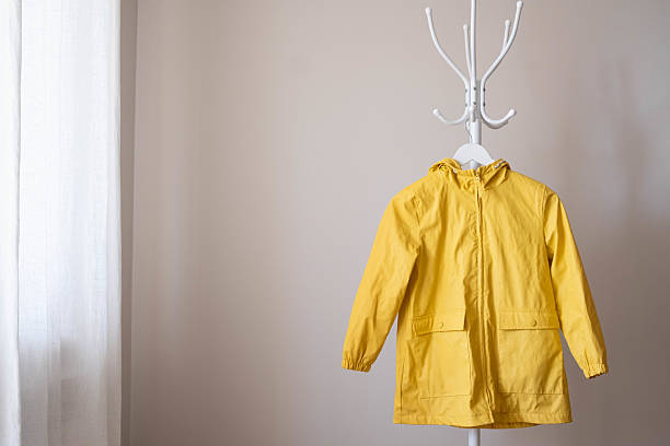 istock A fashionable and stylish bright yellow rain jacket elegantly displayed on a hanger within a modern setting. Autumn clothes. 2233377055