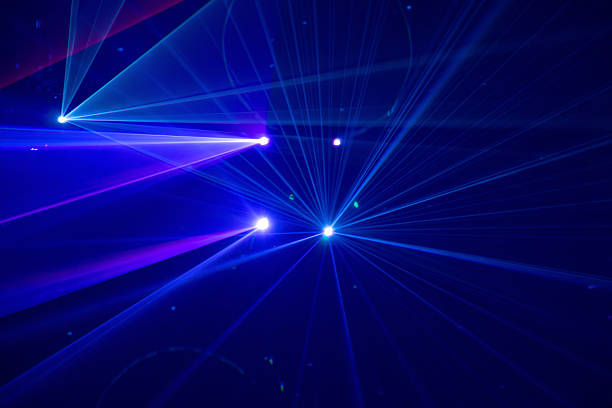 Blue and purple vibrant beams of stage light cutting through the darkness in a dramatic display and a dreamlike quality, creates a minimal yet immersive scene, often seen in concerts, nightclubs, or live performances.