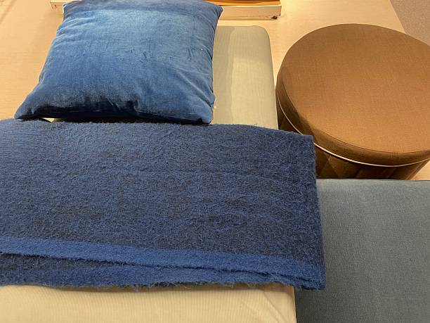 istock Dark Blue Throw Blanket with Black Fringe and Blue Cushion on Bed Display 2233386231