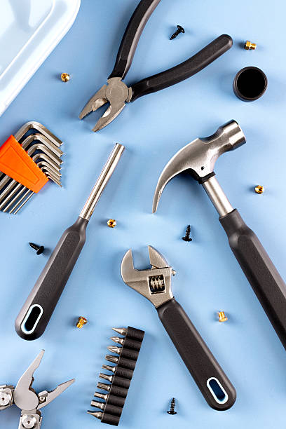 istock Set of hand tools including pliers, wrench, hammer, screwdriver bits scattered on blue. Top view. 2233389924