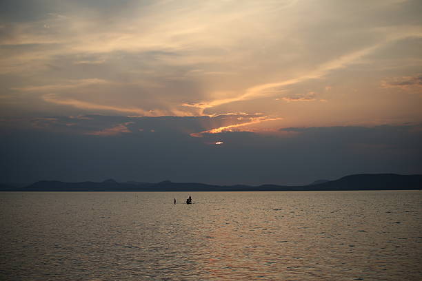 Sunset over lake Balaton with people