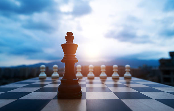 istock Black chess king and white pawns on the chess board 2233391789