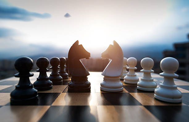istock Two chess knights battle on city background 2233391806