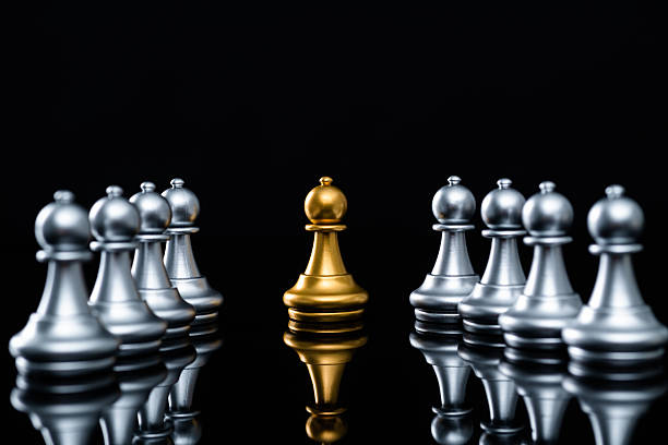 istock One golden pawn and group silver pawns 2233391872