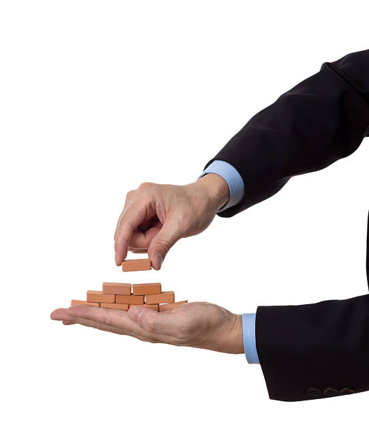 istock Businessman using toy brick build pyramid on hand 2233391957