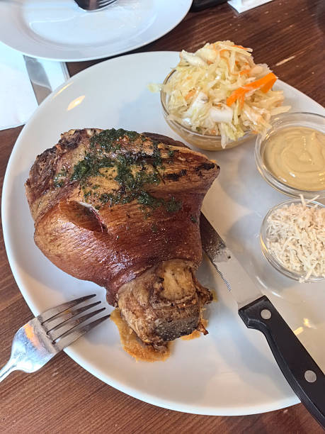 Savory pork knuckle served with side dishes in a cozy eatery setting