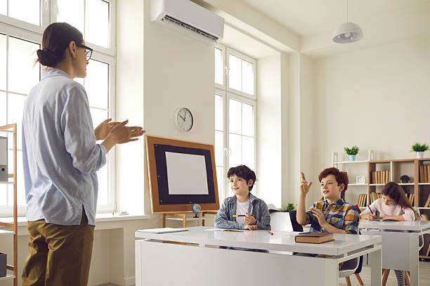 istock Pupil with raised hand ready to answer on teacher question on lesson in class 2233401546