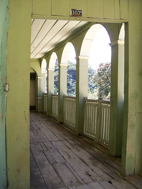 Zaruma, El Oro, Ecuador - August 10, 2007: Wooden porch featuring arches and railings, overlooking lush trees in a serene rural landscape of Zaruma, El Oro, Ecuador, highlighting the charm of local architecture and heritage