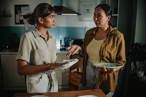 istock Mother and daughter sharing a moment while cleaning up in their cozy home kitchen during a quiet evening 2233414366