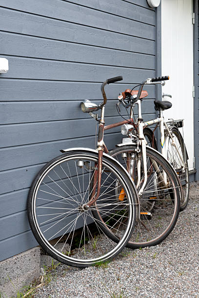 istock Two old vintage bicycles leaning against gray wooden wall 2233414947