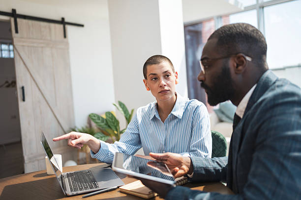 istock Two professionals collaborating in a modern office with technology and laptops 2233415699