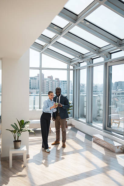 istock Business professionals discussing in a bright, modern office with city views 2233415705