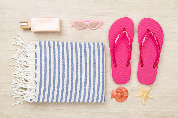 istock Beach towel with summer accessories on wooden background, top view 2233418577