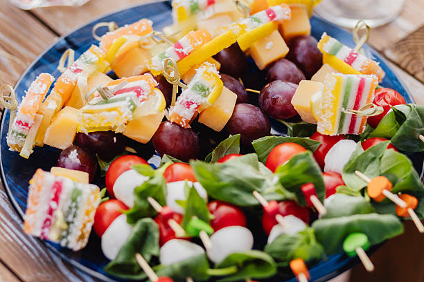 Set of canapes on skewers - a variety of canapes from cheese, berries, vegetables and marmalade