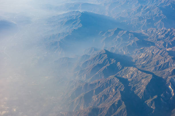 Aerial view of the Andes Mountains covered in snow and the tip of the airplane wing, Chile
