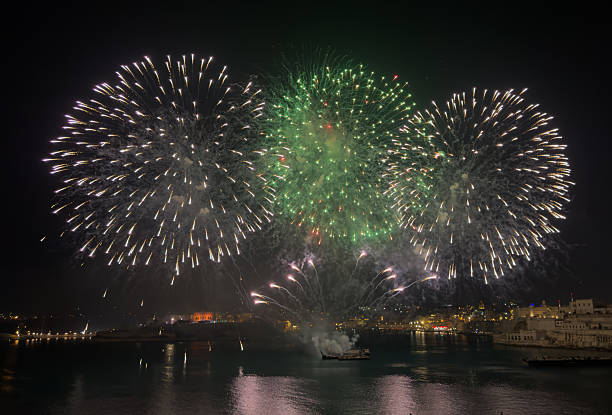 Malta at night with Valletta skyline and fireworks in the background.