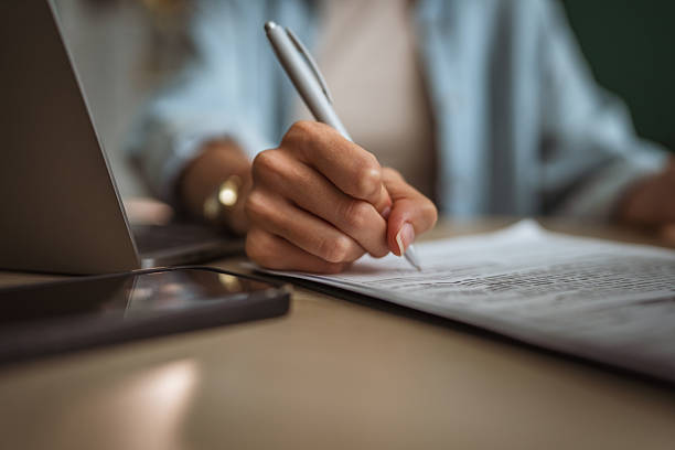 istock Businesswoman writing notes on a document at office desk 2233431368