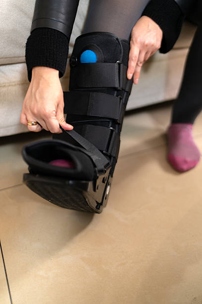 istock Woman adjusting her orthopedic boot at home 2233432751