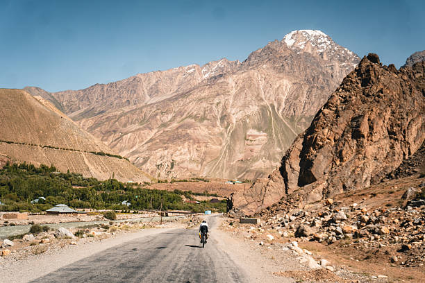 Bikepacker rides remote rural roads, Pamir Highway