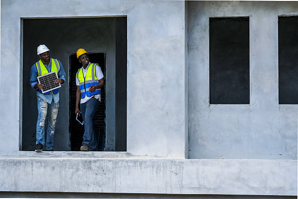Black professionals collaborating on a renewable energy project. A senior engineer and his partner from a Black owned business discuss a solar installation, representing diversity in tech.