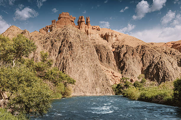 istock Charyn Canyon's breathtaking landscape features unique rock formations, the Sharyn River, and lush vegetation under a cloudy sky in Kazakhstan 2233439513