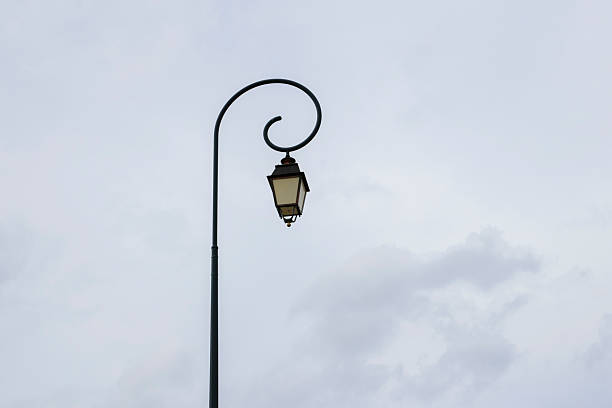 istock Vintage lamp post stands elegantly against a cloudy sky in a charming urban setting 2233439554