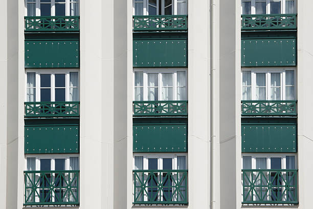 Green balcony design on a modern building facade in urban setting under clear sky