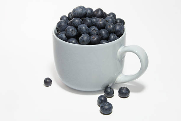istock Ripe blueberries in a large cup on a white background close-up 2233439581