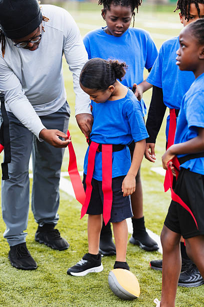 istock Coach helping player put on flag football belt 2233441605
