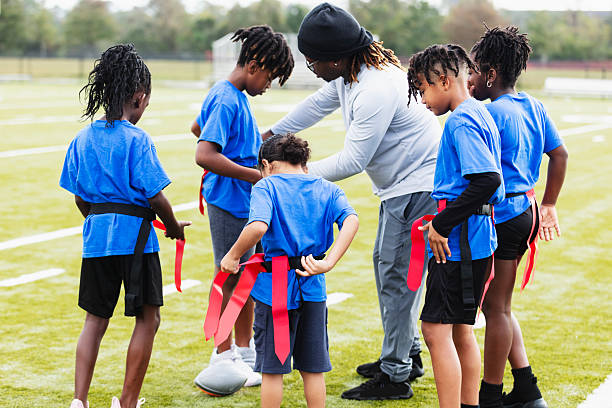 istock Coach helping team put on flag football belts 2233441606