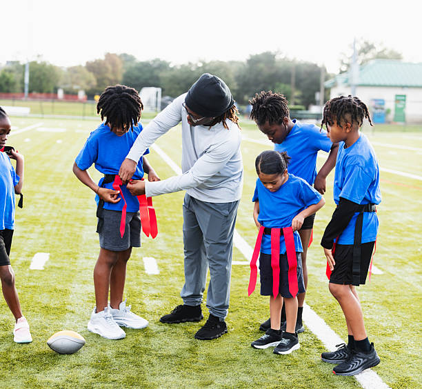 istock Coach helping player put on flag football belt 2233441607