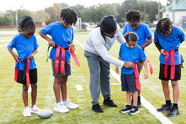 istock Coach helping player put on flag football belt 2233441611