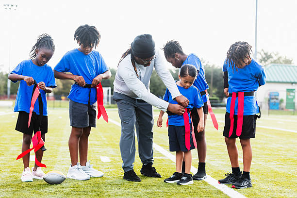 istock Coach helping player put on flag football belt 2233441614