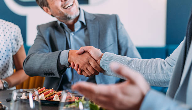 istock Businesspeople shaking hands at the restaurant. 2233444342