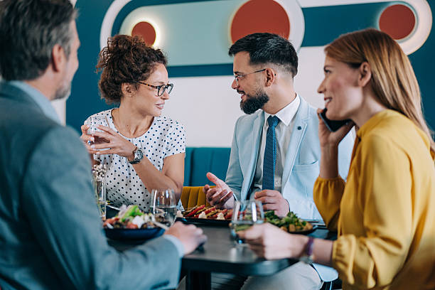 istock Happy business colleagues talking while eating lunch in a restaurant. 2233444350