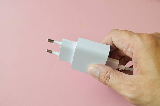 istock Human hand plug in phone battery charger for using charging mobile phone 2233446634