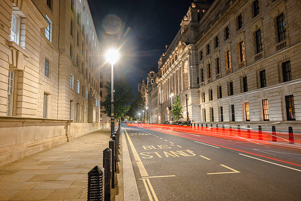 istock Illuminated Street at Night with Moving Vehicles and Classic Architecture 2233446711