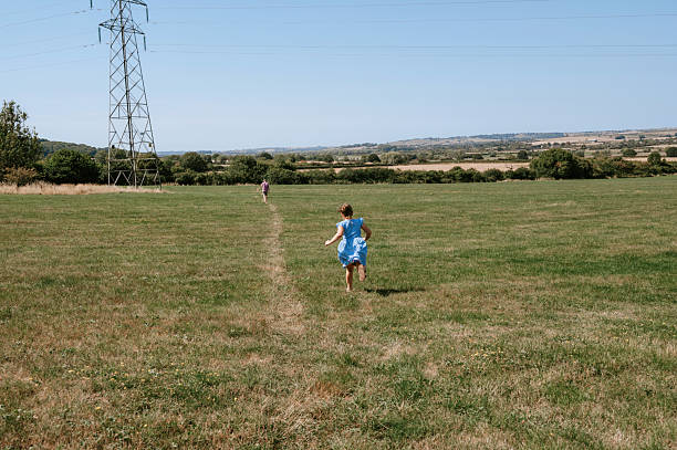 High angle image, taken by drone, depicting a solitary male hiker walking on a rural path in the South Downs national park in East Sussex in southeast England.