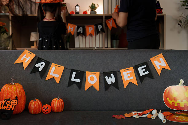 istock Halloween Celebration: Family Decorating with Banners and Pumpkins 2233448068