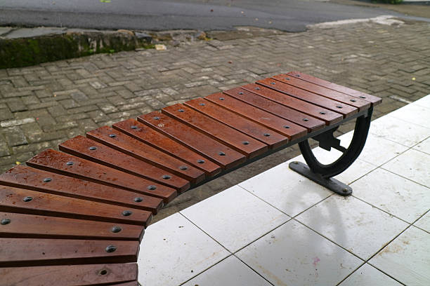 istock Curved Wooden Bench on Tiled Pavement 2233450372