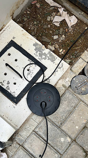 Installation of an Electrical System with a black power Socket and Cable on the Ground