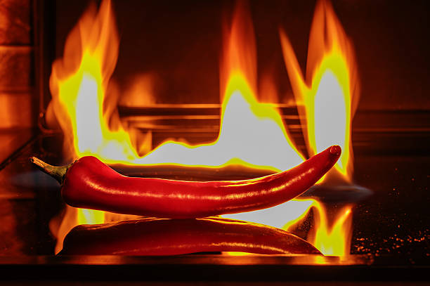 istock Red hot chilli pepper against the background of a burning flame. 2233458454