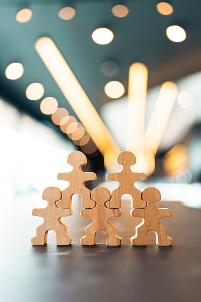 istock Wooden human puzzle pieces connected together in pyramid structure. Concept of teamwork, collaboration, unity, leadership, corporate culture, people connection, and human resource development. 2233458815