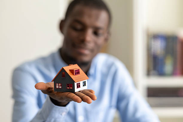 istock Professional real estate agent displaying miniature property model 2233459366