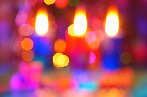 Blurred background. Burning candles and Christmas tree toys.
