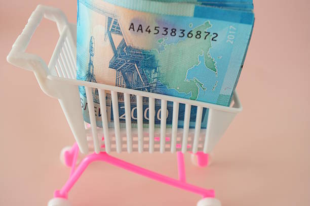 A cart with money on a pink background.