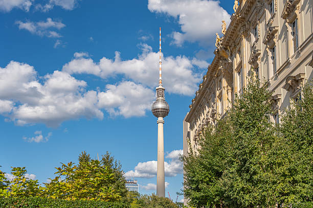 istock The Berlin TV Tower rises between trees and a historic building facade under a bright sky. 2233470935