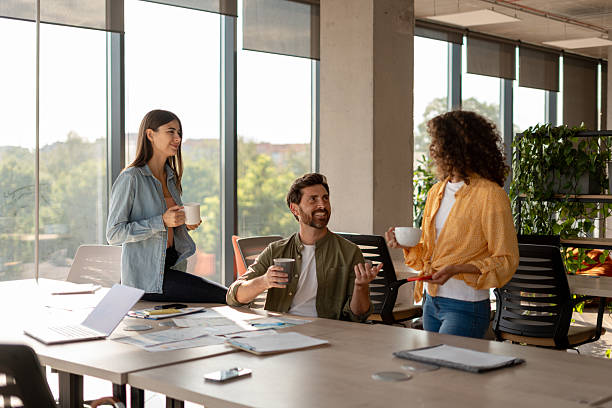 istock Designers enjoying coffee break while discussing project in modern office 2233472337