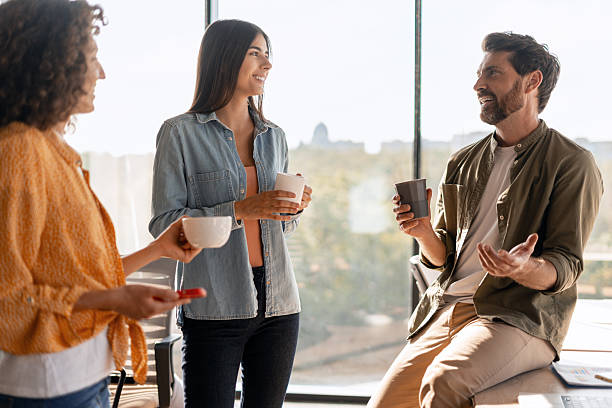 istock Business people enjoying coffee break chatting in modern office 2233472338
