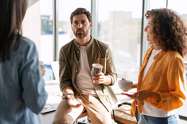 istock Creative business team enjoying coffee break during meeting in modern office 2233472340